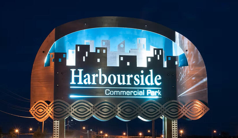 Exterior Sign. Post mounted. Multilayered. Illuminated from within with flood lights.