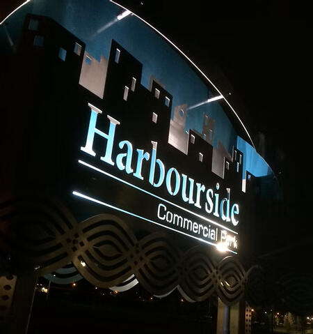 Exterior Sign. Post mounted. Multilayered. Illuminated from within with flood lights.